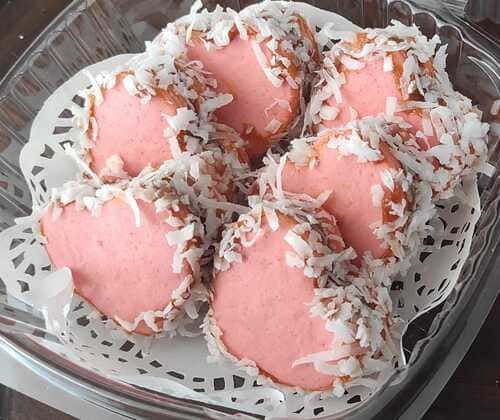 alfajores en forma de corazón rosa, con coco rallado